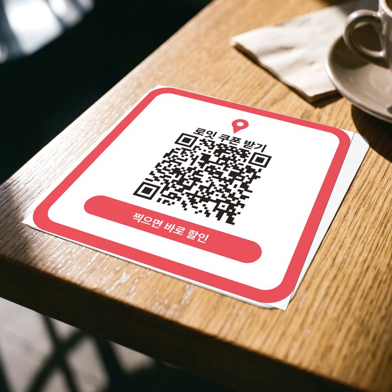 카페 테이블에 붙인 정사각 QR 스티커. 로잇 쿠폰 받기 문구와 QR 코드가 있습니다.